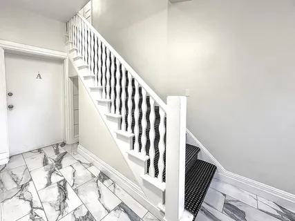 a kitchen with kitchen island white cabinets and wooden floor