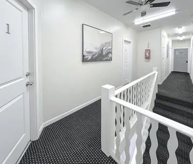 a view of a room with wooden floor and a ceiling fan
