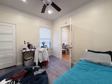 a bedroom with a bed and wooden floor