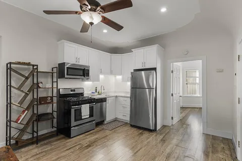 a kitchen with a table chairs refrigerator and cabinets