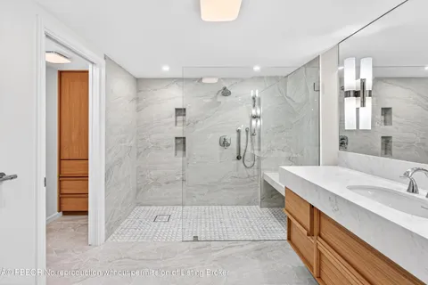 a spacious bathroom with a granite countertop sink a shower and a mirror