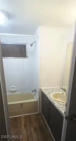 a bathroom with a granite countertop sink and a bathtub