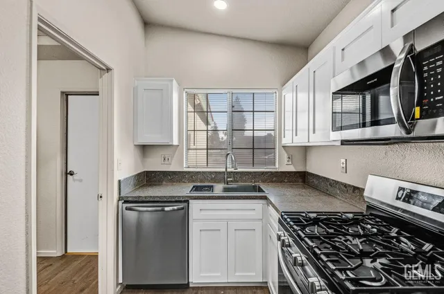 a kitchen with stainless steel appliances granite countertop a stove and a sink