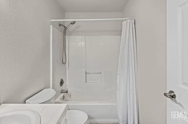 a bathroom with a shower curtain and a sink
