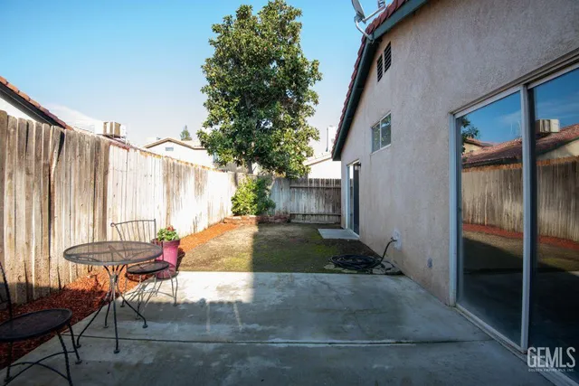 a backyard of a house with table and chairs