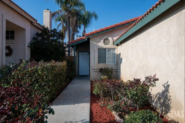 a couple of flower plants in front of house