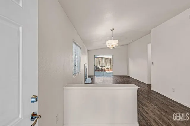 a view of a hallway to a room and a mirror