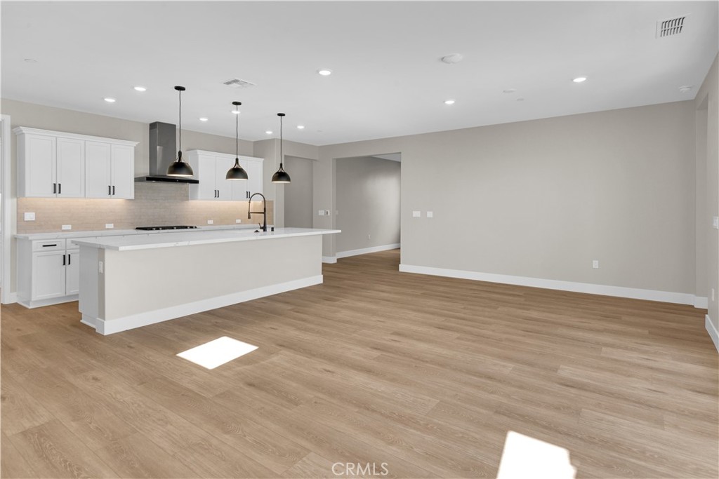 3730 Rosado Road Paso Robles, CA 93446 - Photo 4 of 17 a large white kitchen with kitchen island a sink wooden floor and a chandelier