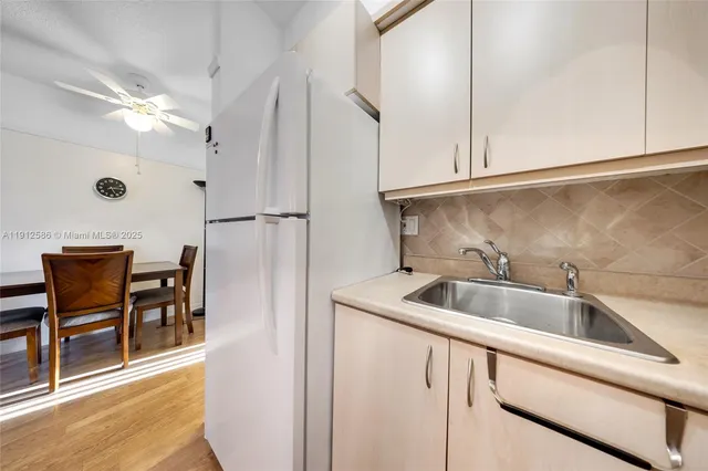 a kitchen with stainless steel appliances granite countertop a sink and a refrigerator