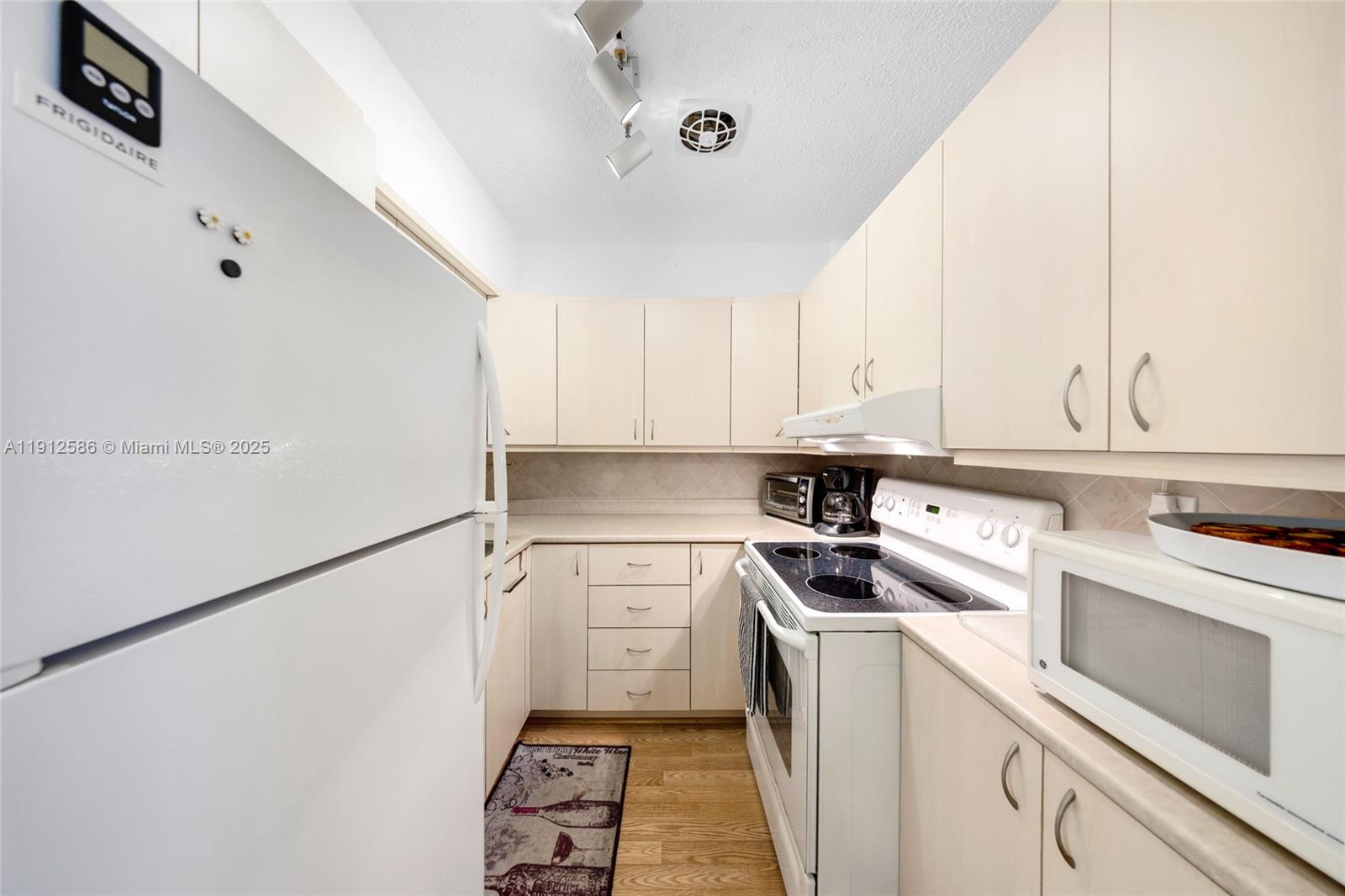 900 Southwest 10th Terrace, Unit 8S Hallandale Beach, FL 33009 - Photo 8 of 33 a kitchen with a sink a stove and cabinets