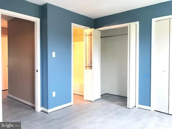 a view of an empty room with closet and a window