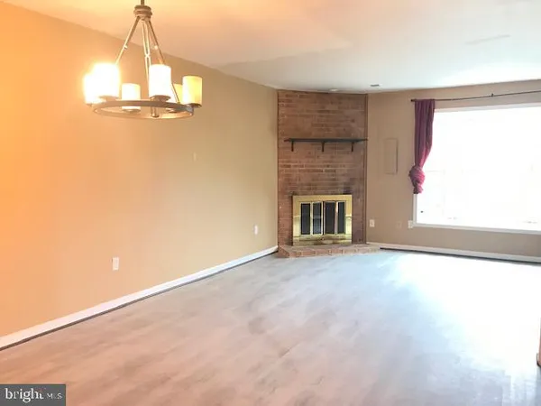 an empty room with windows and fireplace