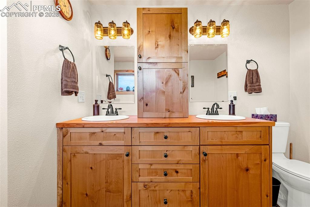 8480 Delaware Road Colorado Springs, CO 80926 - Photo 16 of 49 Bathroom featuring double vanity and toilet