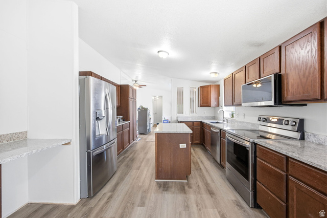 29 Grover Street Layton, UT 84041 - Photo 11 of 29 Kitchen featuring wood-finish flooring, a central island, and abundant wood cabinetry