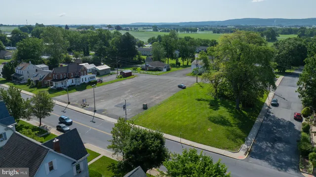 an aerial view of green landscape with trees houses and mountain view