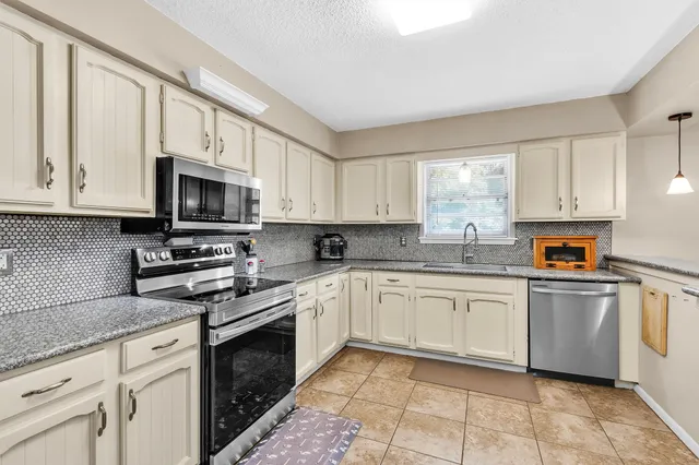 a kitchen with cabinets appliances and a window