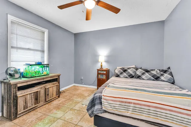 a bedroom with bed and ceiling fan