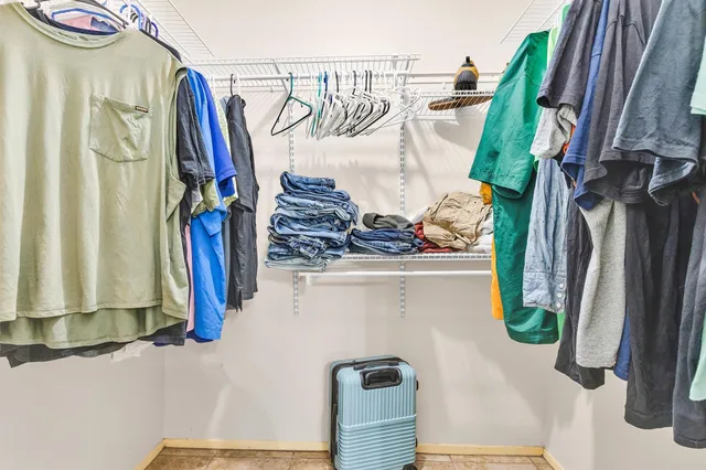a view of walk in closet with clothes and shoes