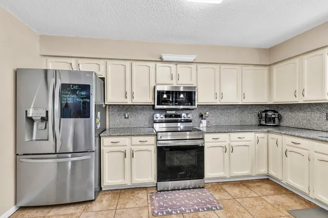 a kitchen with cabinets stainless steel appliances and a window