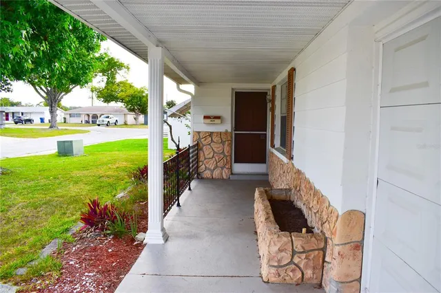 a view of a porch with furniture and garden