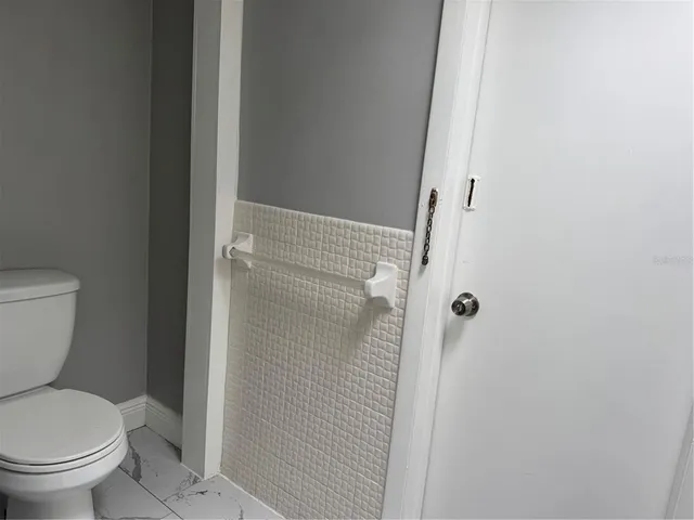 a white toilet sitting next to a shower