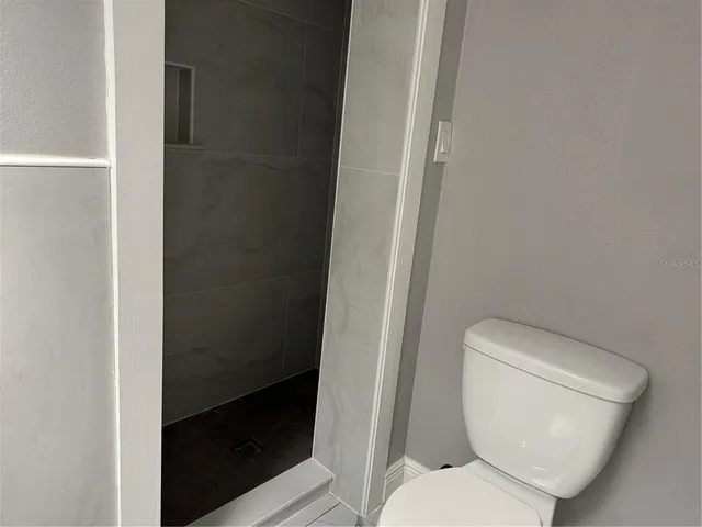 a white toilet sitting next to a shower
