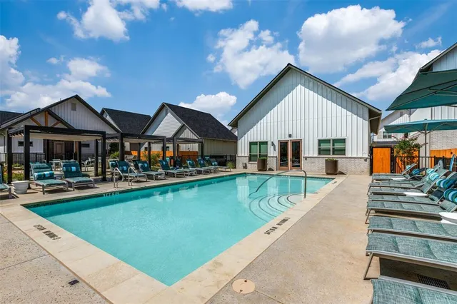 a view of house with swimming pool and outdoor seating