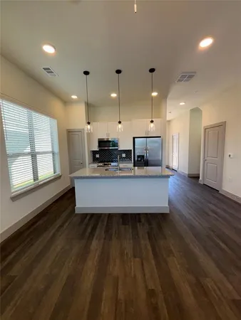 a large kitchen with stainless steel appliances a large counter top