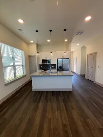 a large kitchen with stainless steel appliances a large counter top