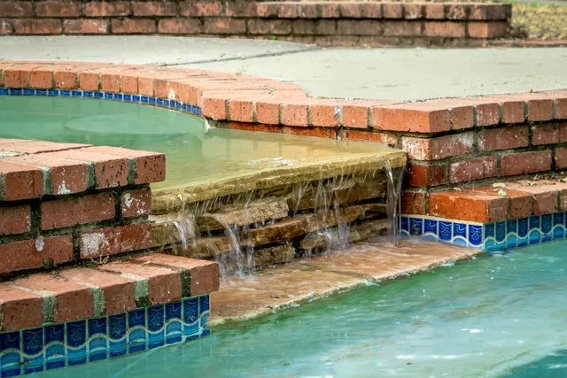 a view of a lake with lawn chairs and a table