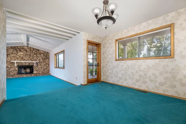 a view of a livingroom with a fireplace and window