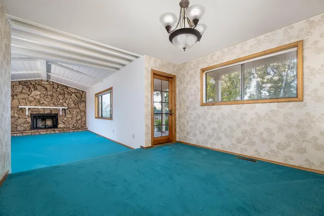 a view of a livingroom with a fireplace and window