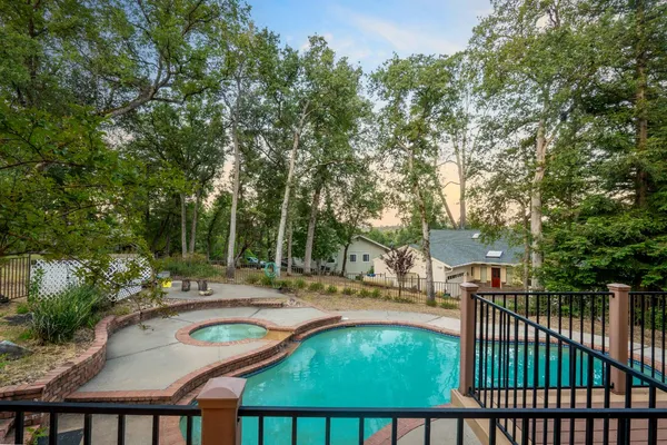 a view of a white house with large trees and outdoor space