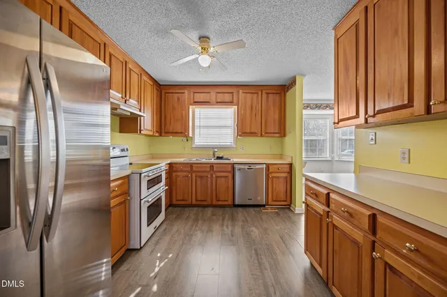 a kitchen with stainless steel appliances sink refrigerator and window