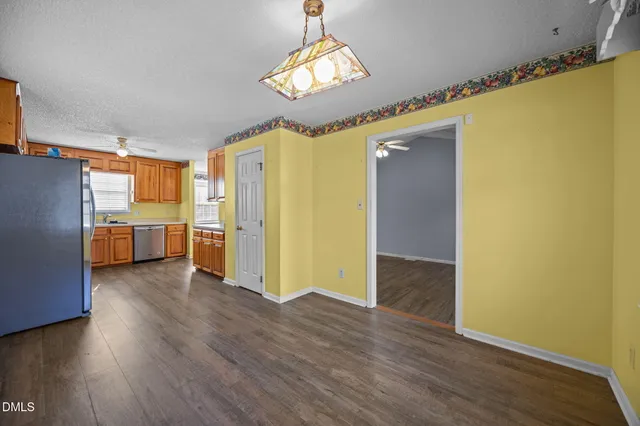 a view of a kitchen with a refrigerator wooden floor and a kitchen