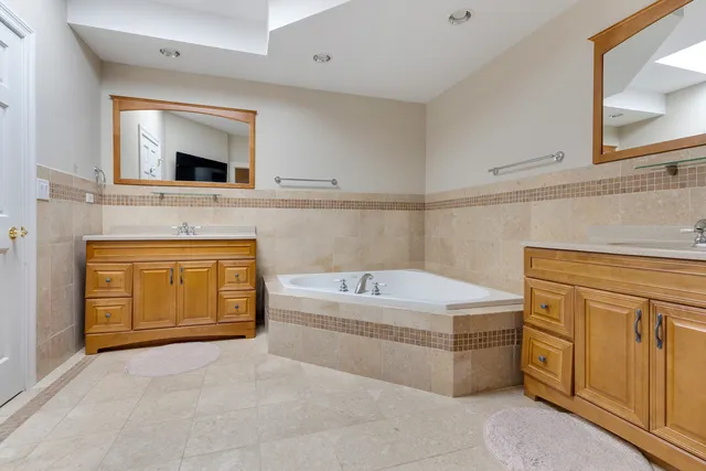 a bathroom with a tub sink and mirror