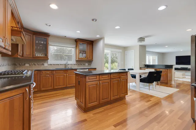 a kitchen with stainless steel appliances granite countertop wooden cabinets a sink and dishwasher with wooden floor