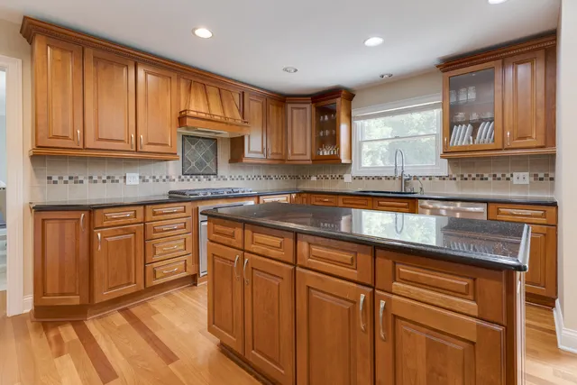 a kitchen with stainless steel appliances granite countertop a stove and a sink