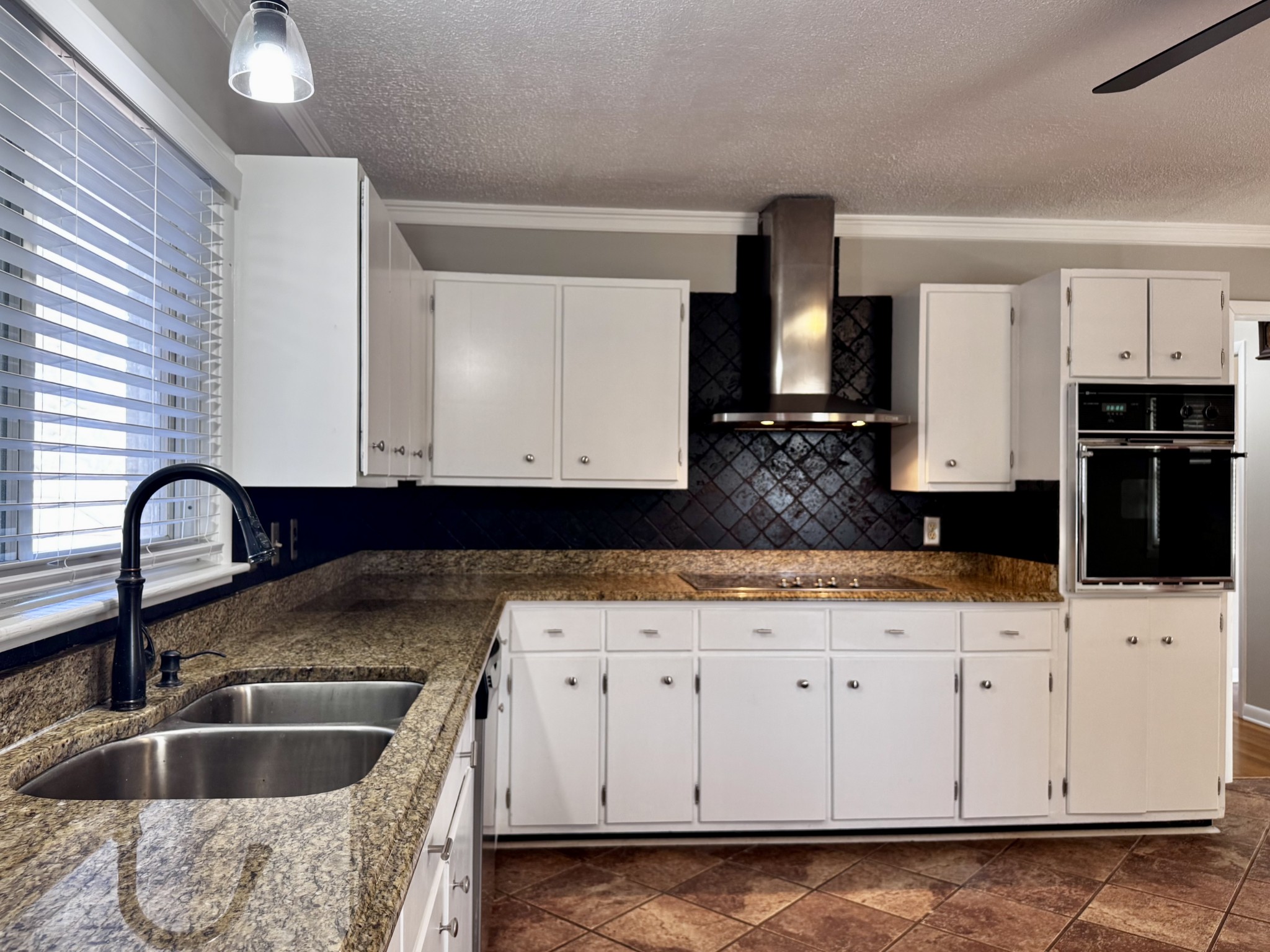 211 Church Street Loretto, TN 38469 - Photo 12 of 37 a kitchen with granite countertop a sink a stove and cabinets
