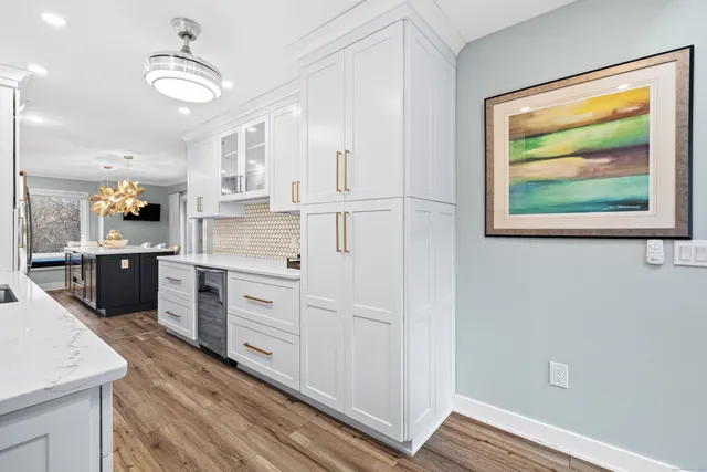 a kitchen with stainless steel appliances white cabinets and wooden floors