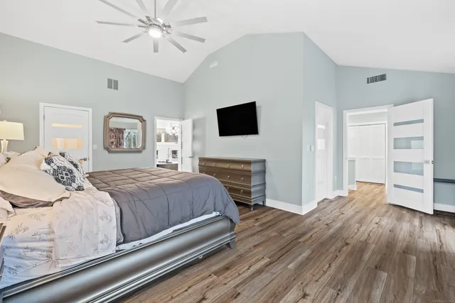 a spacious bedroom with a bed and a flat screen tv