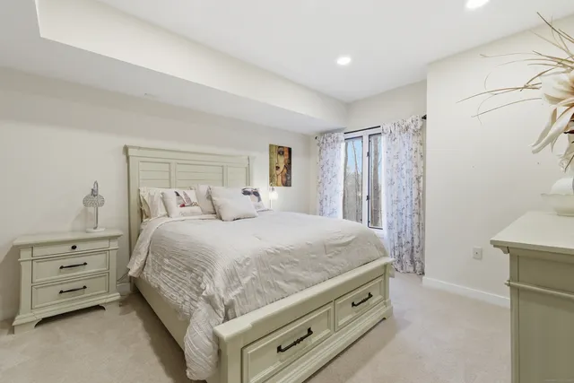 a spacious bedroom with a bed and a dresser
