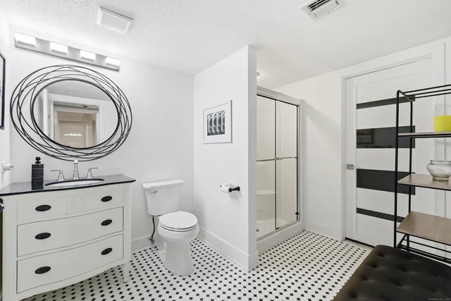 a spacious bathroom with a granite countertop sink a mirror and a toilet