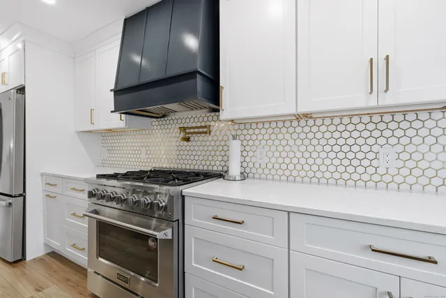a kitchen with granite countertop cabinets stainless steel appliances and wooden floor