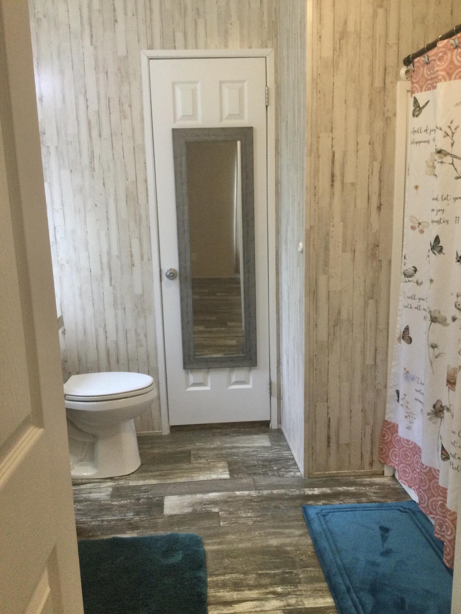 5000 Southeast Federal Highway, Unit 82 Stuart, FL 34997 - Photo 11 of 14 a bathroom with a toilet and a shower