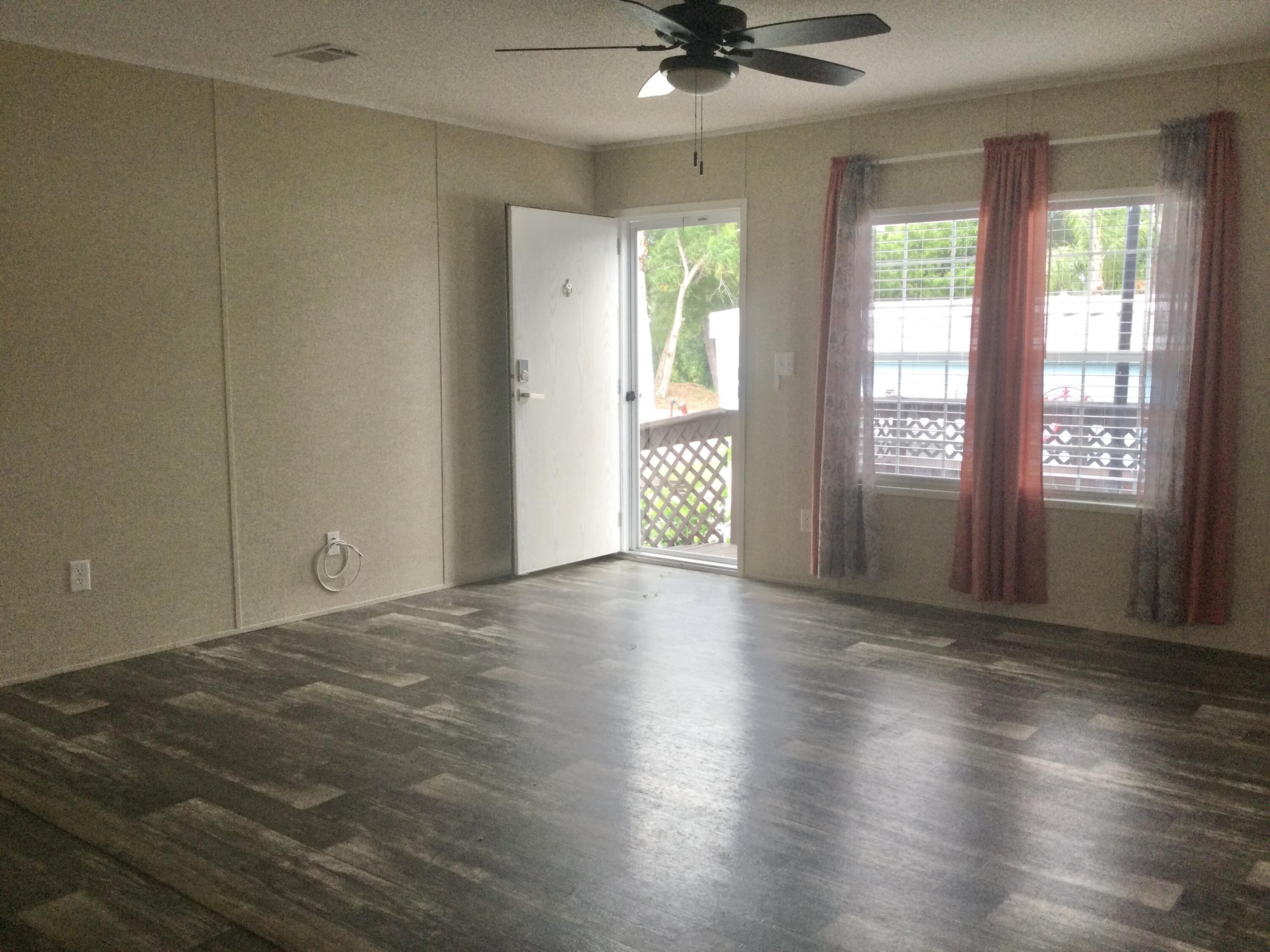 5000 Southeast Federal Highway, Unit 82 Stuart, FL 34997 - Photo 4 of 14 a view of an empty room with a window and wooden floor