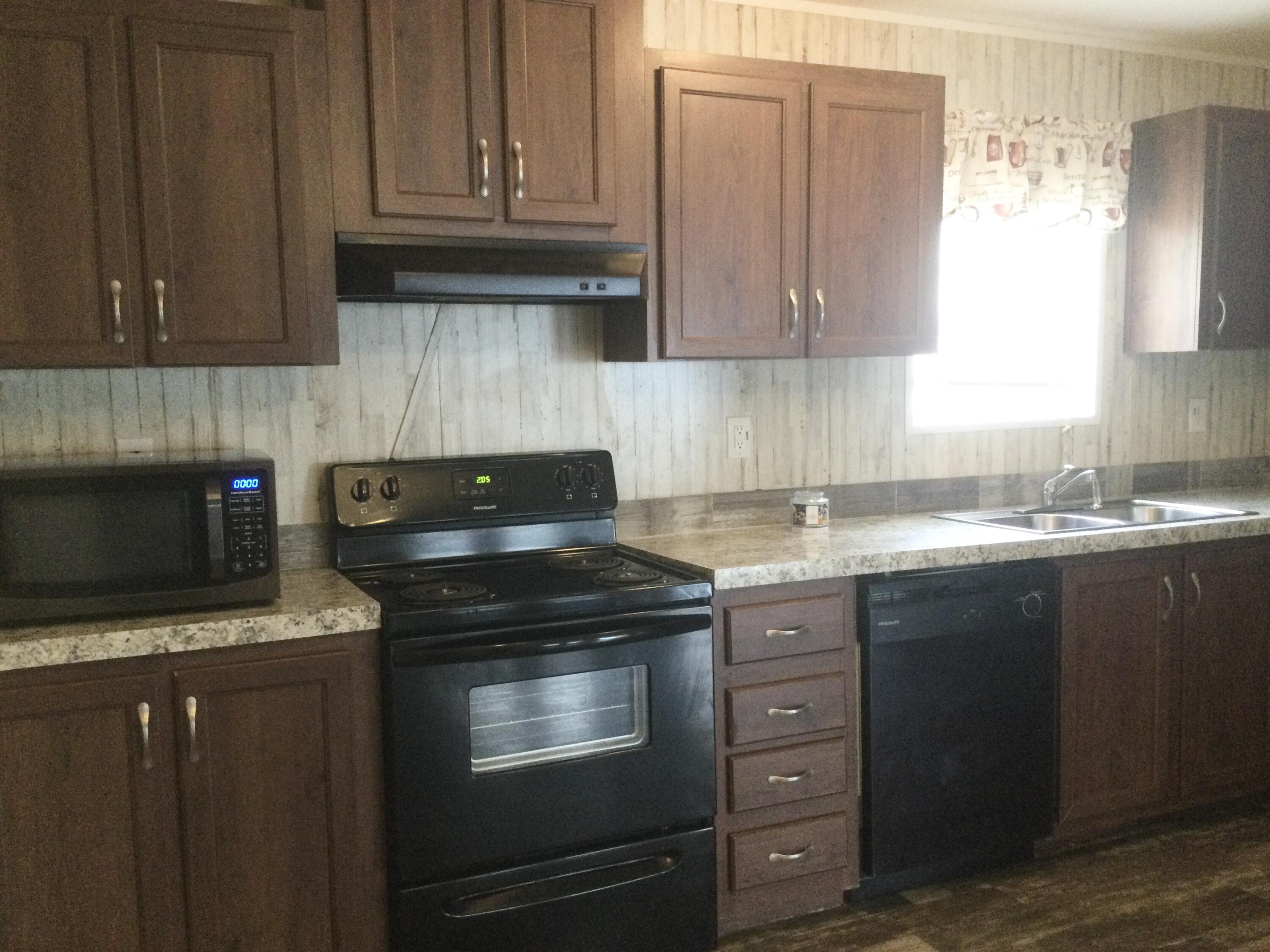 5000 Southeast Federal Highway, Unit 82 Stuart, FL 34997 - Photo 6 of 14 a kitchen with stainless steel appliances granite countertop a stove a sink and a microwave