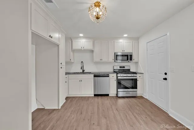 a kitchen with a refrigerator and a stove top oven