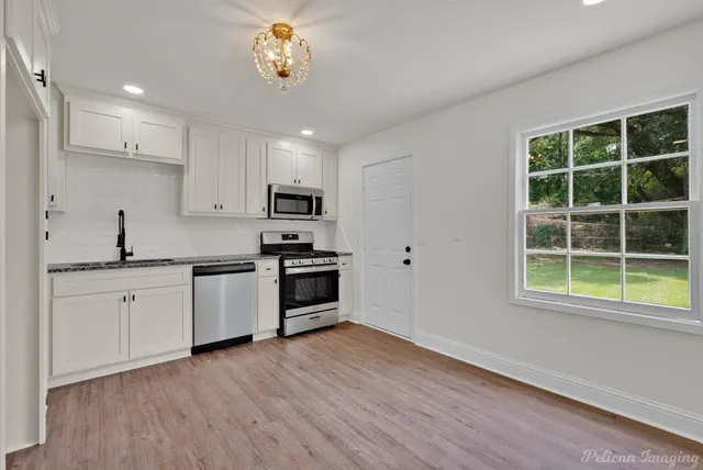 a kitchen with a sink wooden floor and window