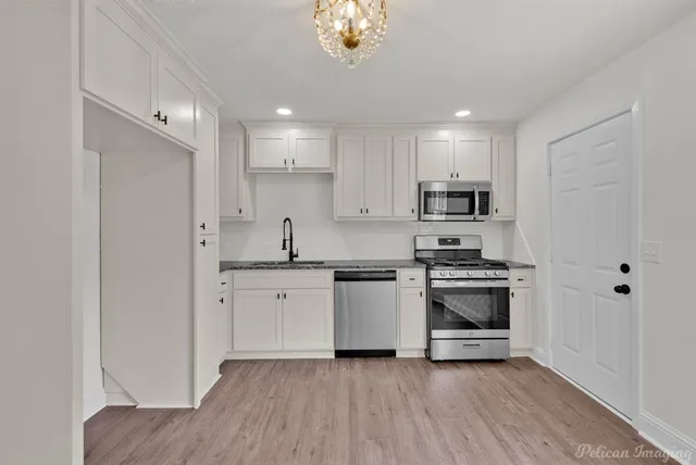 a kitchen with granite countertop a sink stainless steel appliances and cabinets